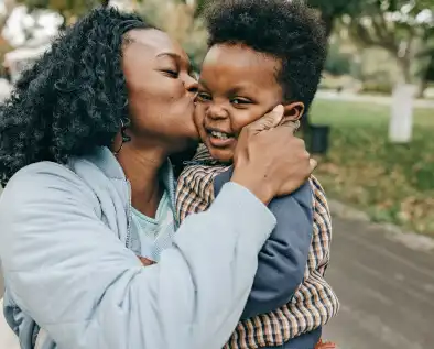 Mother kissing her child happily